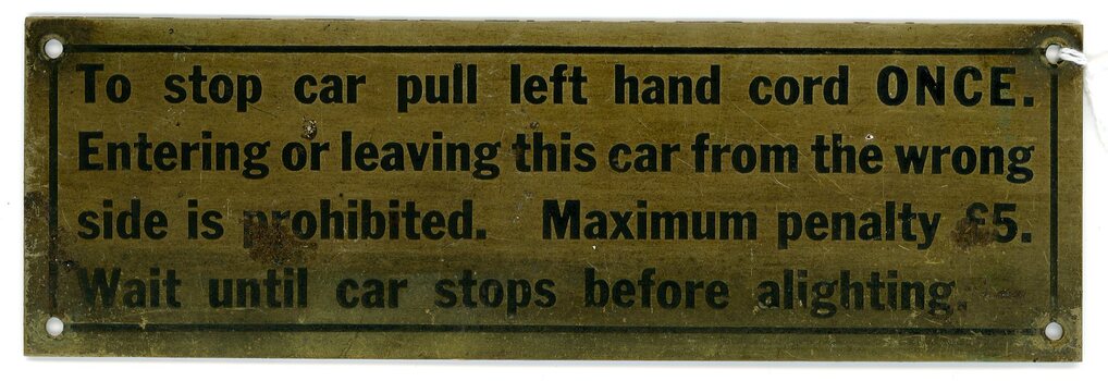 Metal tram sign advising exiting the car procedure.