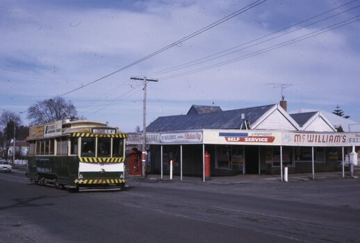 Tram 33 passing a Licensed grocer in 