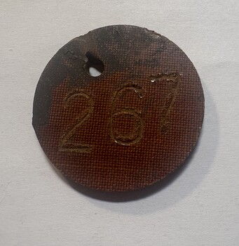 Bakelite disc with engraved number "267"