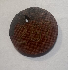 Bakelite disc with engraved number "267"