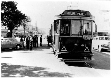 A vintage Australian electric tram numbered 41, marked "SPECIAL" on its front, stands on tracks beside a street with several parked cars and a group of people.