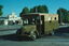 A vintage M&M.T.B. bus with the number 301, painted in brown and tan, parked on a street in front of a light-colored building with the word "ROYALE" visible.
