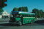 Vintage green and silver bus with "WEST MELBOURNE" displayed above the windshield, parked on a city street with a building in the background.  MMTB bus 370 in Nicholson St with part of the Exhibition buildings.