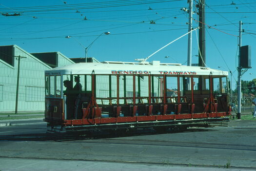 A vintage red and white Bendigo Tramways tram numbered 17, with open-air seating and two people visible in the driver's cabin.