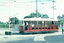 A red and white vintage tram labeled "BENDIGO TRAMWAYS" with the number 17 on the side, travels on tracks at a road intersection.