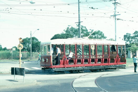 A red and white vintage tram labeled "BENDIGO TRAMWAYS" with the number 17 on the side, travels on tracks at a road intersection.