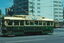 A green and cream vintage tram with the number 14 visible on its side, advertising "Ballarat Tourist Tramway," travels along a city street with modern buildings in the background.