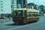 A brown and cream vintage tram with the number 217 displayed prominently, travels along a city street.