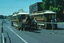 Horse-drawn tram on a street with a cable tram set, with some people.