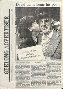 A newspaper clipping titled "GEELONG ADVERTISER" featuring a black and white photo of a man in a tram driver's uniform, being kissed on the cheek by a woman holding a document titled "History of the Geelong Electric Tramways."