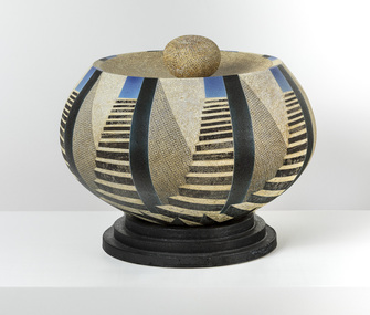 Large ceramic sphere with flat top, separate podium and stone.  Decorated with text and solid stencil, blue and black airbrushed glaze which are applied to look like stair cases leading to a blue sky.