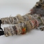 Close up photograph of the woven figure's legs and feet, made from woven feathers, cotton and raffia with crow's feet.