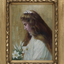 Portrait painting in a gold ornate frame of a girl dressed in white holding white lily flowers. Her head is bowed and her eyes are closed, she has her hair half pulled back with a white bow.