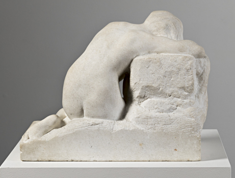 Marble sculpture of naked female slumped onto her knees, with lowered head viewed from the back. She sits on a rectangular base