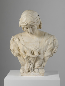 Cream plaster bust of woman. Her hair is parted at the centre, and her head is slightly bowed. She wears a garment with a square neckline. Trumpet lilies cover her bust.