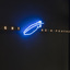 Angled view of a dark wall with a blue and white light artwork installed on it that reads Light as a feather and has a light in the shape of a feather in the centre.