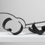 Photograph of a black, welded steel abstract sculpture sitting on a white plinth. Geometric shapes are adjoined to form cluster in roughly horizontal orientation.