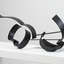 Photograph of a black, welded steel abstract sculpture sitting on a white plinth. Geometric shapes are adjoined to form cluster in roughly horizontal orientation.
