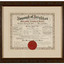 Framed certificate in mainly black, red and gold ink on cream paper, with decorative floral border. Gives details of the municipality and has a red wax seal at bottom of certificate. Has a cream mount and carved timber frame.