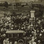A large group of people surrounding a small memorial fountain on the left which is being unveiled by the Mayoress. To the right is the large bronze statue of Sir Thomas Bent which stands on a tall granite pedestal. In the foreground is an early 20th century car. Paddocks and houses can be seen in the distance.