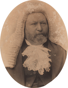 Oval shaped sepia toned portrait photograph of a bearded man from chest up, he is wearing a white wig and a lace jabot at front of a dark suit.