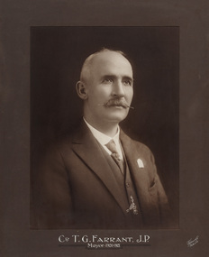 Sepia photograph of a formal portrait of seated man, chest up, wearing a 3 piece suit.S