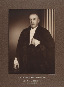 Sepia photograph of a formal portrait of standing man wearing mayoral robes with fur trims and lace cuffs and jabot.