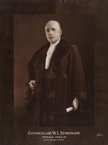 Sepia photograph of formal portrait of balding man, standing, wearing mayoral robes with fur trims and lace cuffs and jabot.
