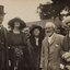 Sepia photograph of 5 people including a man with a top hat, 2 women and 2 other men.