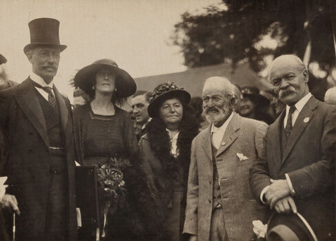 Sepia photograph of 5 people including a man with a top hat, 2 women and 2 other men.