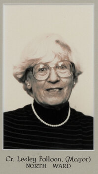 Black and white photographic portrait of a woman with short white hair and glasses.