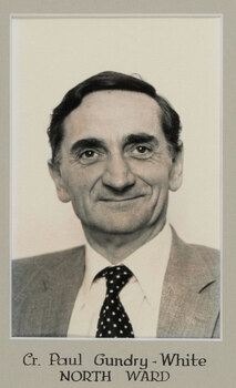 Black and white photographic portrait of a man with dark hair in a suit and tie