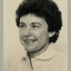 Black and white photographic portrait of a woman with short dark hair and a white shirt.