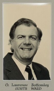 Black and white photographic portrait of a man in a dark suit and tie 