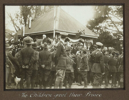 Black and white photograph, soldiers in foreground, stage in background.