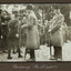Black and white photograph of 2 men in bowler hats greeting a row of soldiers in uniform.