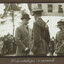 Black and white photograph of The Prince, in a bowler hat, shaking hands with a uniformed soldier