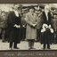 Black and white photograph of three men, men on left (Town clerk) and right (Mayor) wear ceremonial robes, man in centre (The Prince) is in bowling hat