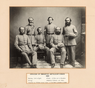 Gelatin silver photograph of uniformed men, three standing and three seated, looking towards the camera. Below the photograph is an inscription listing sitters.