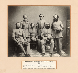 Gelatin silver photograph of uniformed men, three standing and three seated, looking towards the camera. Below the photograph is an inscription listing sitters.