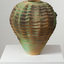 Vase with wavy pattern in bronze and green tones on a white plinth