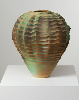 Vase with wavy pattern in bronze and green tones on a white plinth