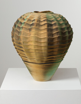 Vase with wavy pattern in bronze and green tones on a white plinth