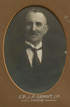 Black and white photograph of a man in a dark suit and patterned tie