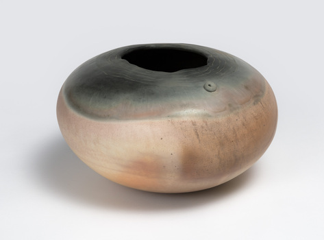 A round terracotta vase in pink and grey tones.