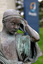Close up of a metal sculpture of a child holding a shell to his ear