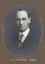 Black and white photograph of an oval portrait of a man in a suit with dark hair