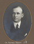 Black and white photograph of an oval portrait of a man in a suit