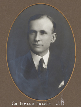 Black and white photograph of an oval portrait of a man in a suit