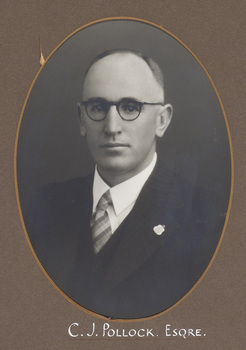 Black and white oval portrait photograph of a balding man with glasses in a suit